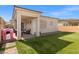 Landscaped backyard featuring artificial grass, a covered patio, and a charming pink playhouse at 8668 Marcana St, Las Vegas, NV 89166