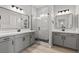 Modern bathroom with dual vanities, a glass-enclosed shower, and marble-like tile at 8668 Marcana St, Las Vegas, NV 89166