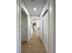 Bright hallway leading to a kitchen and features white walls, light vinyl floors and closet space at 9369 Villa Ridge Dr, Las Vegas, NV 89134