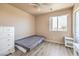 Bright bedroom with a modern ceiling fan, light wood floors, and a sunny window at 978 Valetta Flat Ave, Las Vegas, NV 89183
