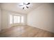 Bright bedroom featuring wood floors, ceiling fan, and a large bay window at 10321 Marymont Pl, Las Vegas, NV 89134