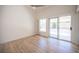 Bright living room featuring wood floors, vaulted ceiling, and sliding glass door to backyard at 10321 Marymont Pl, Las Vegas, NV 89134