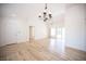 Bright living room with wood floors, chandelier, and sliding glass door to backyard at 10321 Marymont Pl, Las Vegas, NV 89134
