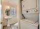 Bathroom with pedestal sink, window, and stacked washer and dryer at 1034 Tam O Shanter, Las Vegas, NV 89109