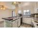 The kitchen features white cabinets, bar seating, granite countertops, and stainless steel appliances at 1034 Tam O Shanter, Las Vegas, NV 89109