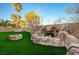 Beautiful backyard featuring a rock waterfall, artificial grass and a fire pit at 10530 Eagle Nest St, Las Vegas, NV 89141