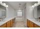 A luxurious bathroom boasts dual vanities, a soaking tub, and abundant natural light from the glass-block window at 10530 Eagle Nest St, Las Vegas, NV 89141