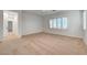 A spacious bedroom with neutral carpeting offers a serene retreat with large windows and abundant natural light at 10530 Eagle Nest St, Las Vegas, NV 89141