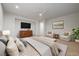 A staged main bedroom with a TV, armchairs, and a comfortable king-sized bed presents a cozy and relaxing space at 10530 Eagle Nest St, Las Vegas, NV 89141