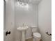 Bright powder room with pedestal sink, modern lighting, and toilet at 10530 Eagle Nest St, Las Vegas, NV 89141