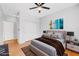 Staged bedroom featuring a ceiling fan, closet, wood floors, and a comfortable queen-size bed at 11356 Belmont Lake Dr # 103, Las Vegas, NV 89135
