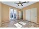 Bedroom boasts wood flooring, neutral walls, sliding glass door to backyard, and ceiling fan at 11356 Belmont Lake Dr # 103, Las Vegas, NV 89135