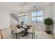 Charming dining area with a modern chandelier, comfortable seating, and a view to the outside, next to stairs at 11356 Belmont Lake Dr # 103, Las Vegas, NV 89135