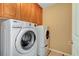Bright laundry room with Whirlpool washer and dryer and cabinets above at 11356 Belmont Lake Dr # 103, Las Vegas, NV 89135