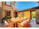 Staged patio area with a wooden dining table and chairs set up for outdoor dining at 11356 Belmont Lake Dr # 103, Las Vegas, NV 89135
