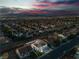 Aerial view of the home featuring solar panels, three-car garage, and beautifully lit exterior at 1136 Casady Hollow Ave, Henderson, NV 89012