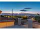 View from a balcony shows a residential neighborhood and distant city lights at dusk with a cloudy sky at 1136 Casady Hollow Ave, Henderson, NV 89012