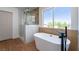 Contemporary bathroom featuring a freestanding tub, glass-enclosed shower, and natural light at 1136 Casady Hollow Ave, Henderson, NV 89012