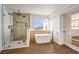 Bathroom showcases a glass-enclosed shower, freestanding tub, and a large window with a scenic view at 1136 Casady Hollow Ave, Henderson, NV 89012