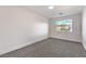 Minimalist bedroom featuring neutral carpet, white trim, and a bright window with views at 1136 Casady Hollow Ave, Henderson, NV 89012