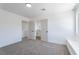 Bright bedroom featuring neutral carpet, white walls, and an ensuite bathroom with double doors at 1136 Casady Hollow Ave, Henderson, NV 89012