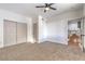 Bright bedroom with neutral carpet, large closet, ceiling fan, and connecting view to the kitchen at 1136 Casady Hollow Ave, Henderson, NV 89012