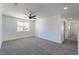 Spacious carpeted bedroom with ceiling fan and natural light from the window at 1136 Casady Hollow Ave, Henderson, NV 89012