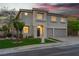 Beautiful two-story home with well-manicured lawn, desert landscaping, and warm exterior lighting at 1136 Casady Hollow Ave, Henderson, NV 89012