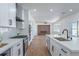 Open concept kitchen with stainless steel appliances, quartz countertops, and a view of the living area at 1136 Casady Hollow Ave, Henderson, NV 89012