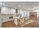Modern kitchen features white cabinets, stainless steel appliances, an island with bar seating, and wood-look flooring at 1136 Casady Hollow Ave, Henderson, NV 89012