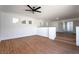 Naturally lit living room displaying wood-style flooring, ceiling fan fixture and multiple windows at 1136 Casady Hollow Ave, Henderson, NV 89012