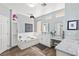 This gorgeous bathroom has a tub, and dual sinks with a vanity that has marble countertops and wood tile floors at 11550 Velicata Ct, Las Vegas, NV 89138