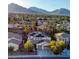 Aerial view of a neighborhood showcasing a home with solar panels surrounded by lush landscaping and mountain views at 11550 Velicata Ct, Las Vegas, NV 89138