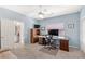 Bright home office featuring a large desk, ceiling fan, and adjacent bathroom for added convenience at 11550 Velicata Ct, Las Vegas, NV 89138