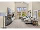 Spacious living room with a stone fireplace, large windows, and neutral decor at 11550 Velicata Ct, Las Vegas, NV 89138