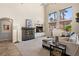 Living room featuring a stone fireplace, vaulted ceiling, and tile flooring at 11550 Velicata Ct, Las Vegas, NV 89138