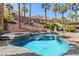 Beautiful blue swimming pool and spa surrounded by mature landscaping, creating a private backyard oasis at 11550 Velicata Ct, Las Vegas, NV 89138