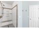 Walk-in shower features white tiling, a rainfall shower head, a bench, and a shampoo niche for storage at 11550 Velicata Ct, Las Vegas, NV 89138