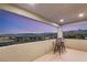 Relaxing balcony with seating overlooking the city lights and mountain views at dusk at 11943 Rockview Point St, Las Vegas, NV 89138