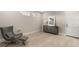 Neutral living room featuring a gray arm chair, cabinet, decorative mirror and flowers on the accent table at 11943 Rockview Point St, Las Vegas, NV 89138