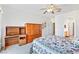 Bright bedroom with a ceiling fan, matching wood wardrobe and desk, and floral bedding at 1199 Golf Club, Laughlin, NV 89029