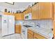 Bright kitchen featuring white appliances, tile countertops, and ample wood cabinets at 1199 Golf Club, Laughlin, NV 89029