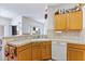 Kitchen with tile countertops, white appliances, wood cabinets, and adjacent dining area at 1199 Golf Club, Laughlin, NV 89029