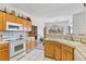 Kitchen with white appliances, tile countertops, and wood cabinets open to dining room at 1199 Golf Club, Laughlin, NV 89029