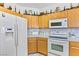 Kitchen with white appliances, tile countertops, and ample wood cabinets at 1199 Golf Club, Laughlin, NV 89029