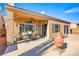 Covered patio featuring an outdoor dining set, ceiling fan, and desert landscaping at 1199 Golf Club, Laughlin, NV 89029