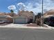 Charming single-story home with a red door, two-car garage, and landscaped front yard at 1249 Lucia Dr, Las Vegas, NV 89128