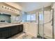 Well-lit bathroom featuring granite countertops, a walk-in shower, and a large bathtub at 127 Mauve St, Henderson, NV 89012