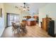 Open dining area with wood floors, ceiling fan, access to kitchen, and views to outdoor patio at 127 Mauve St, Henderson, NV 89012