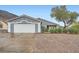 A single-story home with a two-car garage, desert landscaping, and mountain views in the background at 127 Mauve St, Henderson, NV 89012